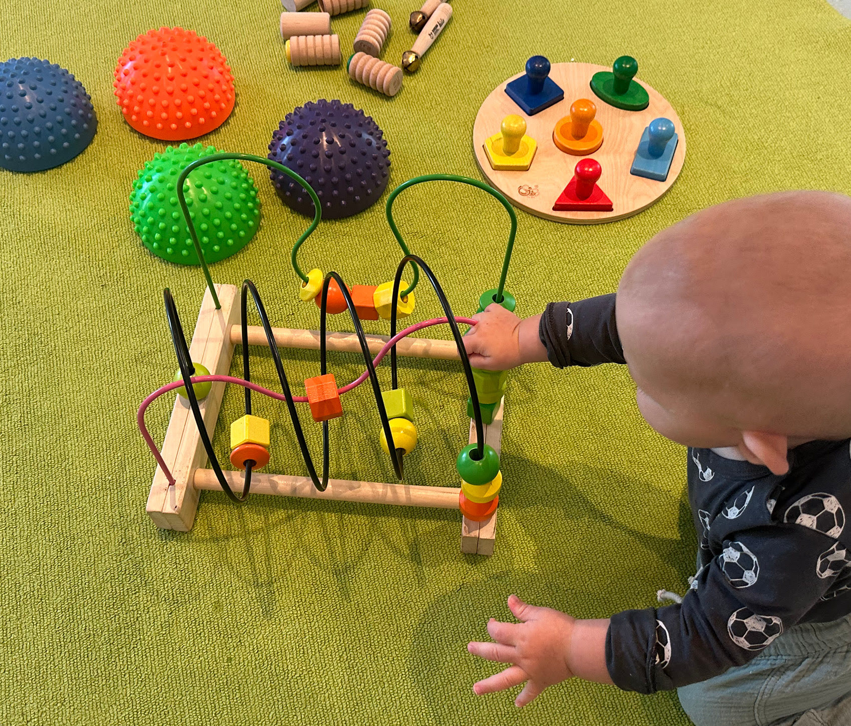 Baby spielt mit einem Geschicklichkeitsspiel in der Mama-Baby-Spielgruppe